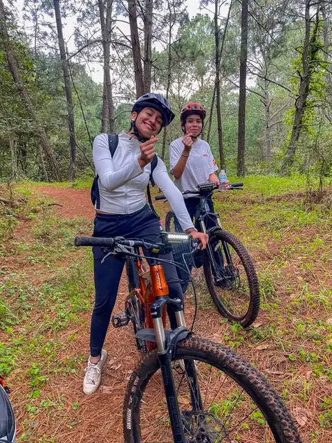 Ciclistas sonriendo durante una pausa en el bosque