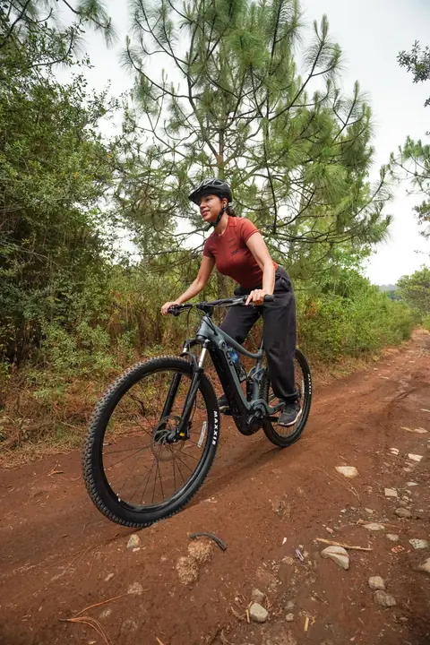 Ciclista en ascenso por un camino de bosque